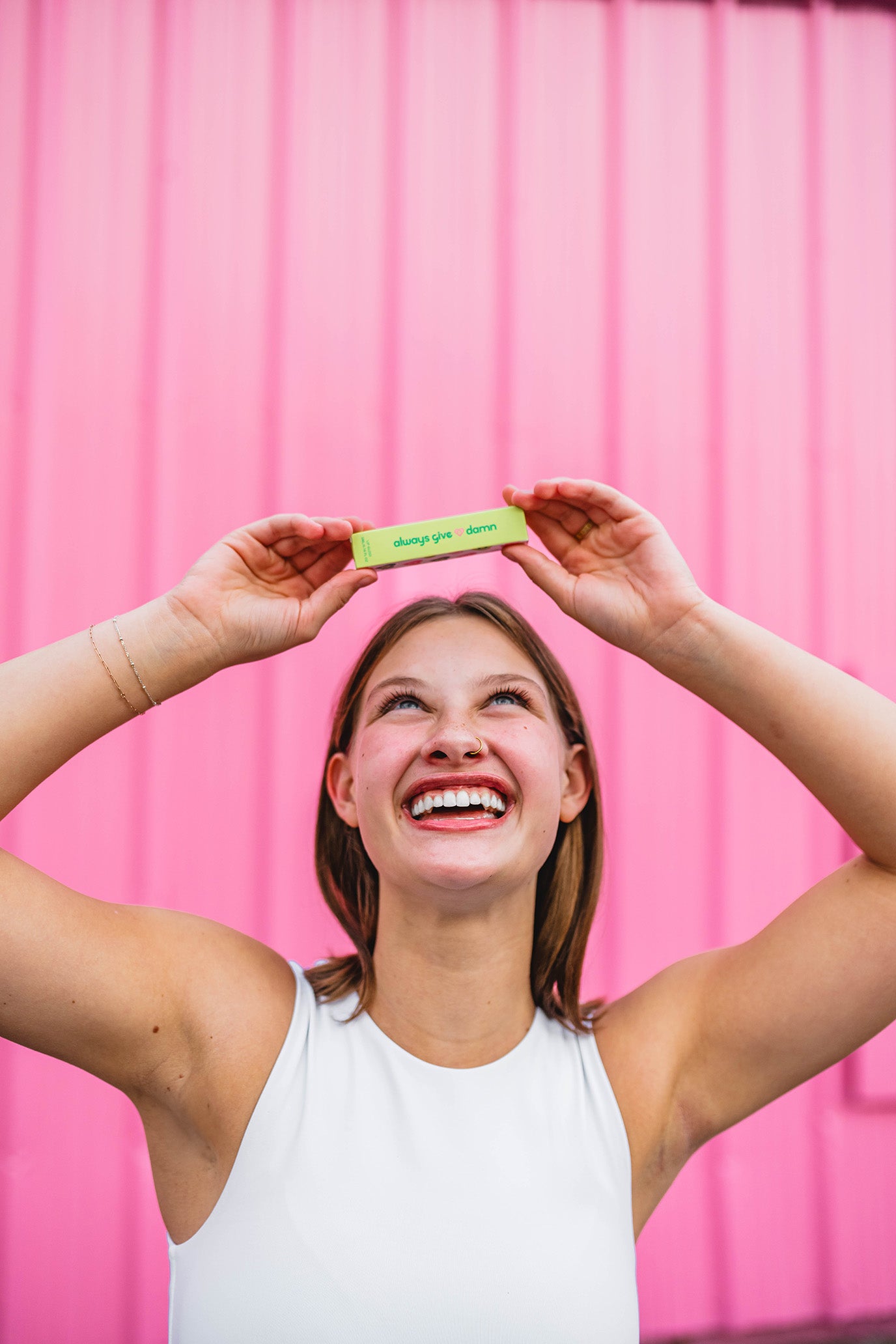 Founder Avery holding up Always Give a Damn lip gloss package