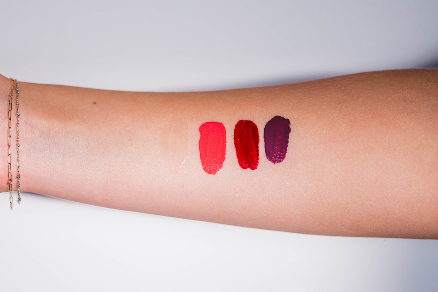 Swatch of all four shades including clear, pink, red, and purple