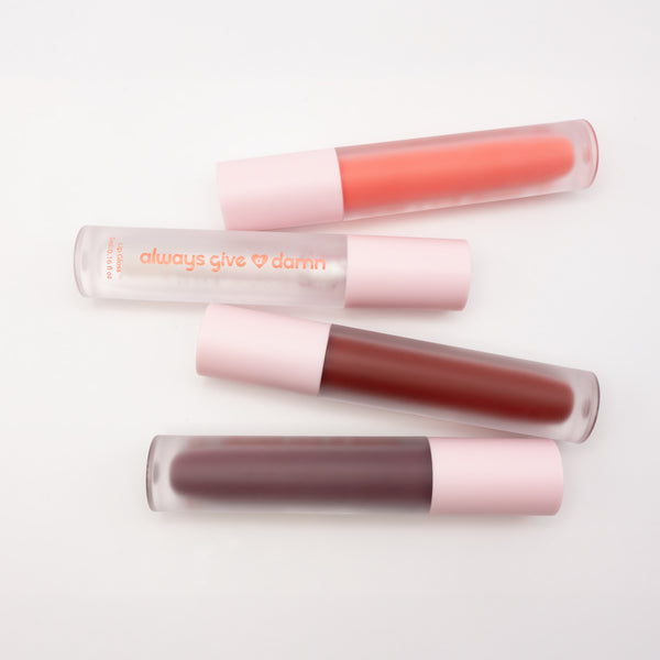 Four lip glosses featuring pink, clear, red, and purple